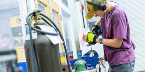 A man with a purple shirt in a machine room 