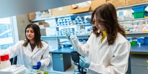 Two scientists in white lab coats work in a laboratory.
